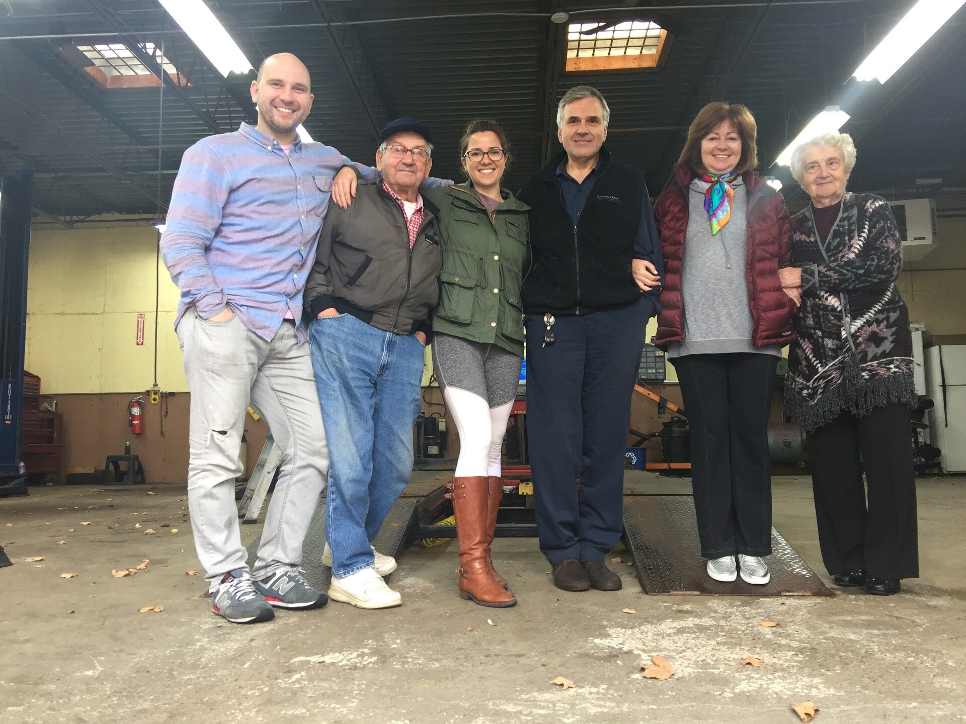 Six people standing together inside the KG Auto Repair service bay